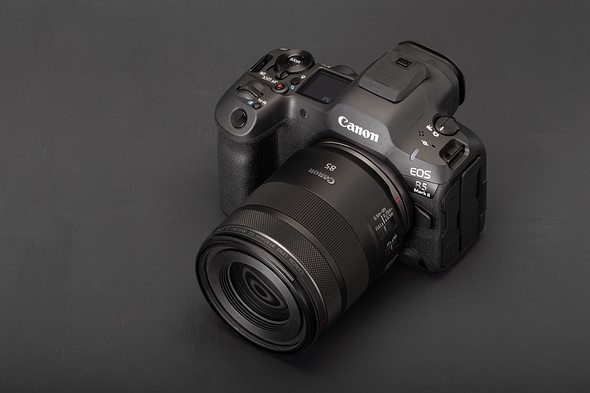 Photo of the Canon EOS R5 II with an 85mm lens attached against a grey background