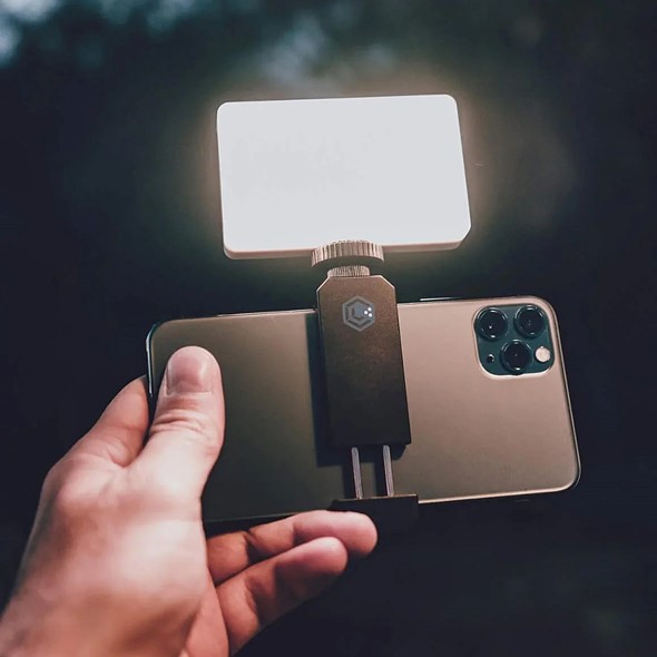 hand holds out phone with light panel attached