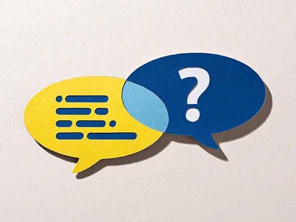 a yellow word bubble with blue lines overlaps a blue one with a white question mark both are placed on a textured off white paper