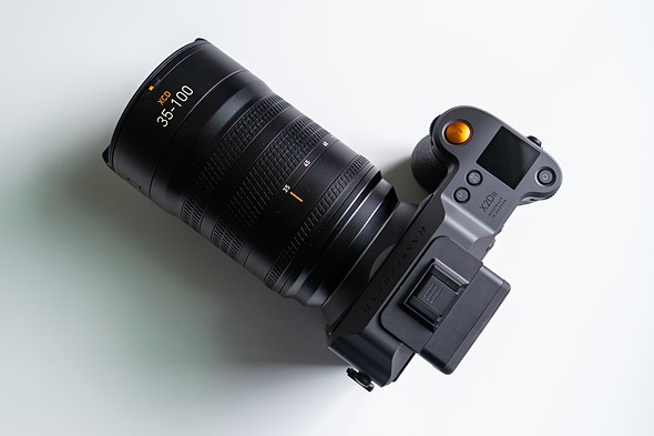 a hasselblad camera with lens is sitting on a white table 5 
