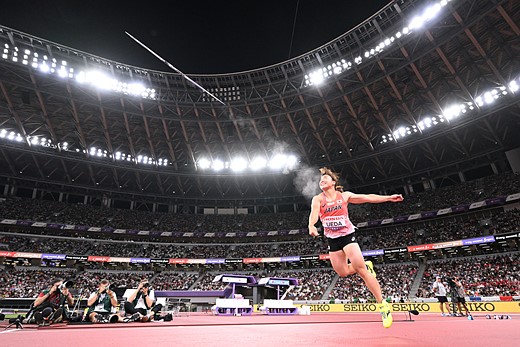 a person throws a javelin in the middle of a stadium