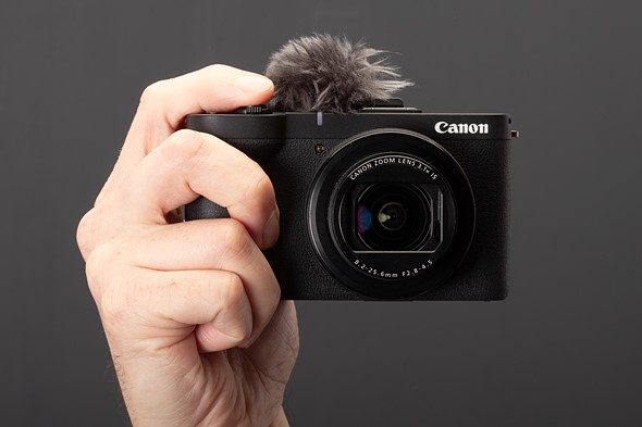 hand holding canon compact camera