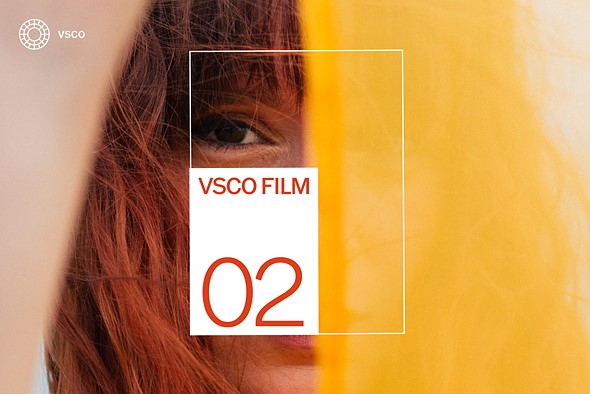awhite box with red text is around the eye of a person with red hair surrounded by a yellow scarf