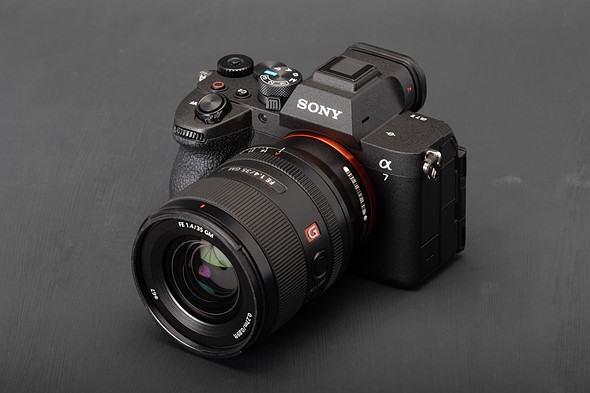 a black sony camera is on a brushed black surface
