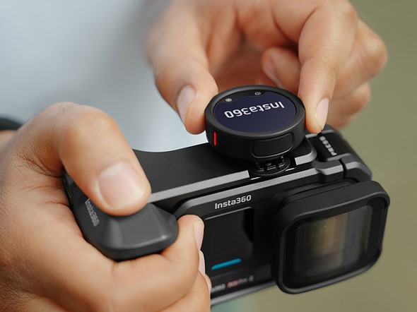 an insta360 mic pro its on top of a insta360camera while hands adjust it